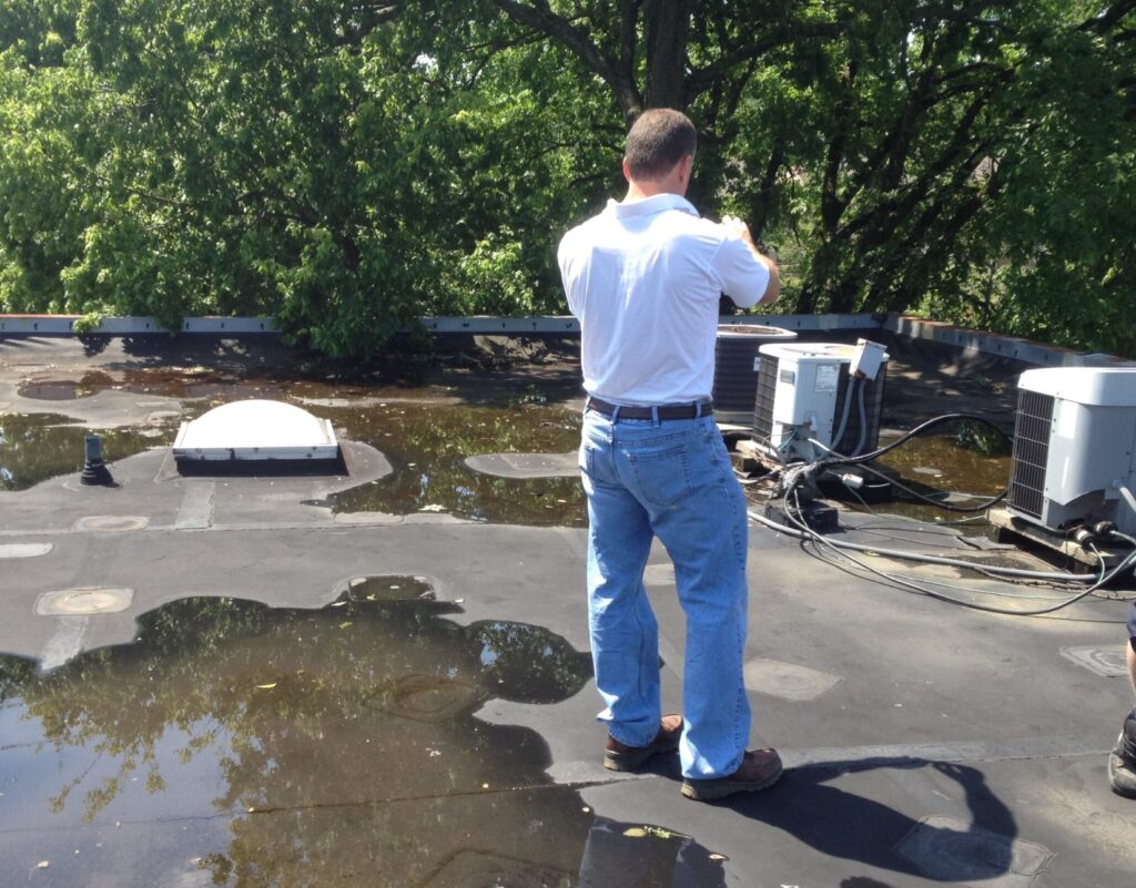 Commercial roof inspection showing ponding water and aging low-slope roofing system